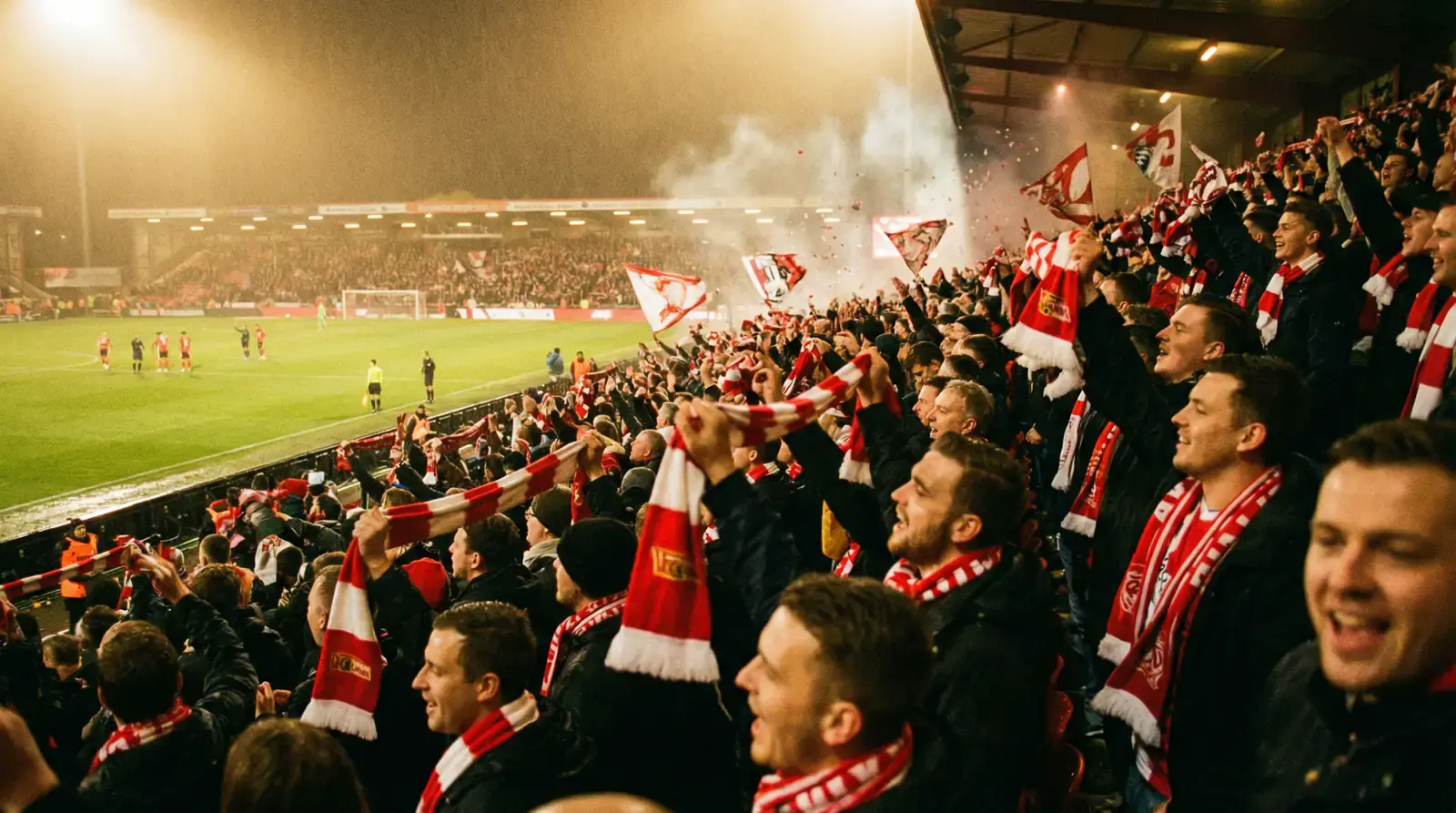 Nadšení futbaloví fanúšikovia na tribúne s vlajkami počas medzinárodného zápasu
