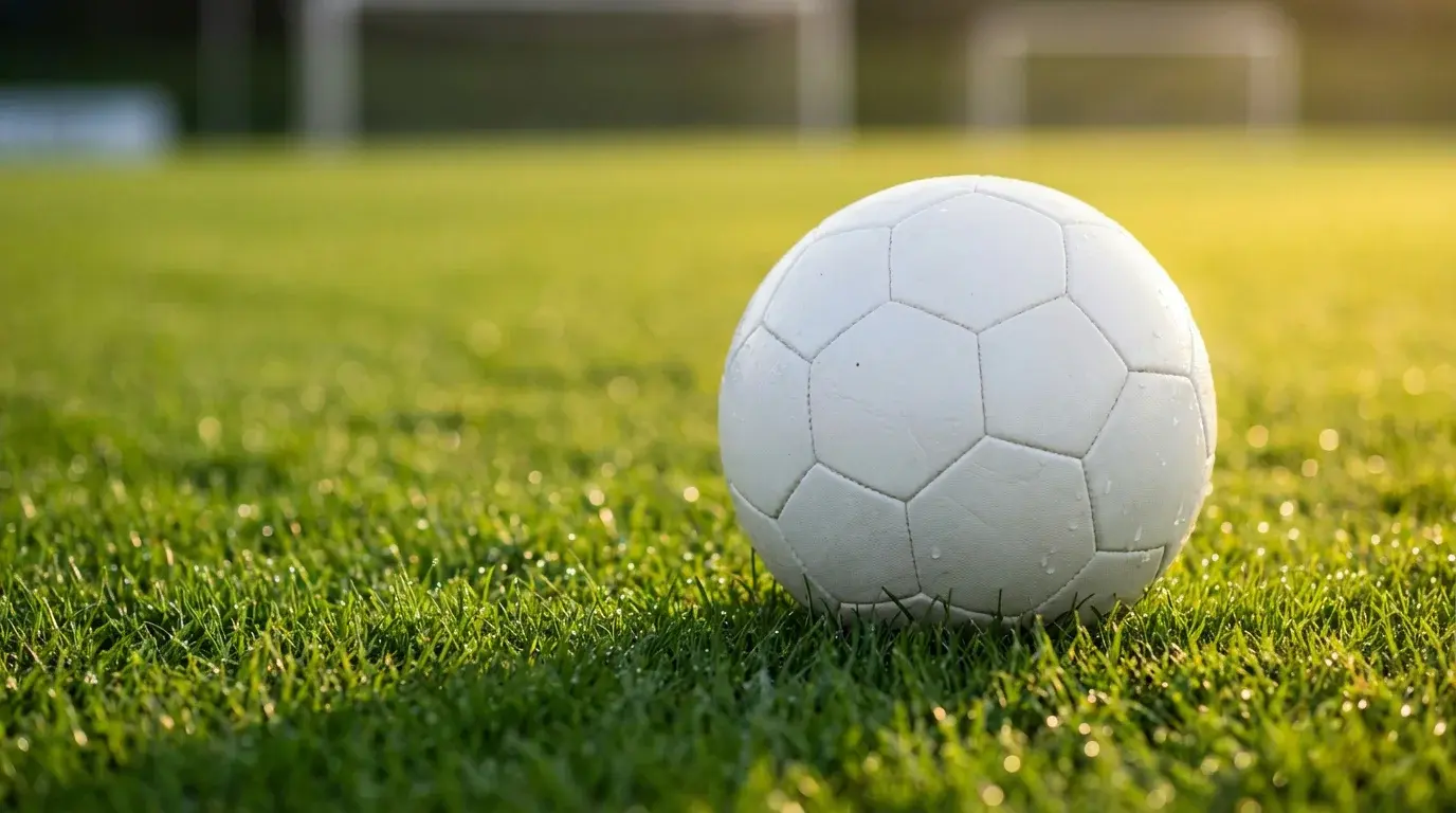 Detail futbalovej lopty na zelenom trávniku pred výkopom zápasu